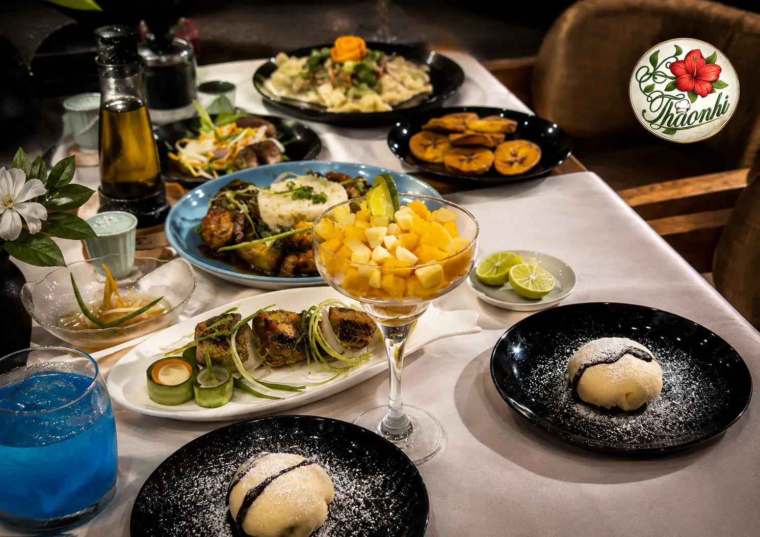 Table garnie de plats vietnamiens, salade de fruits et desserts chez ThaoNhi